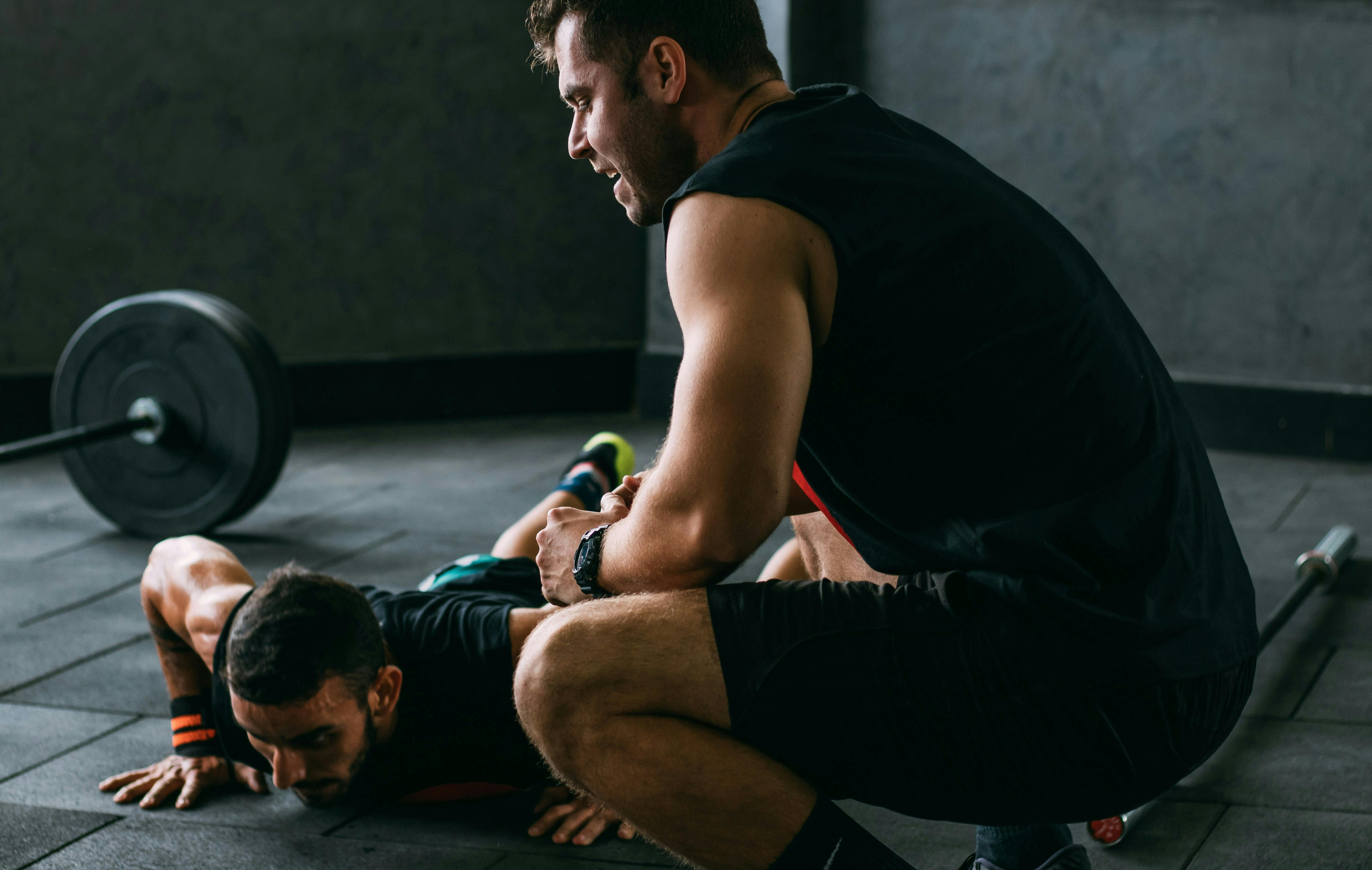 Personal trainer supervising a client during a strength-training session.
