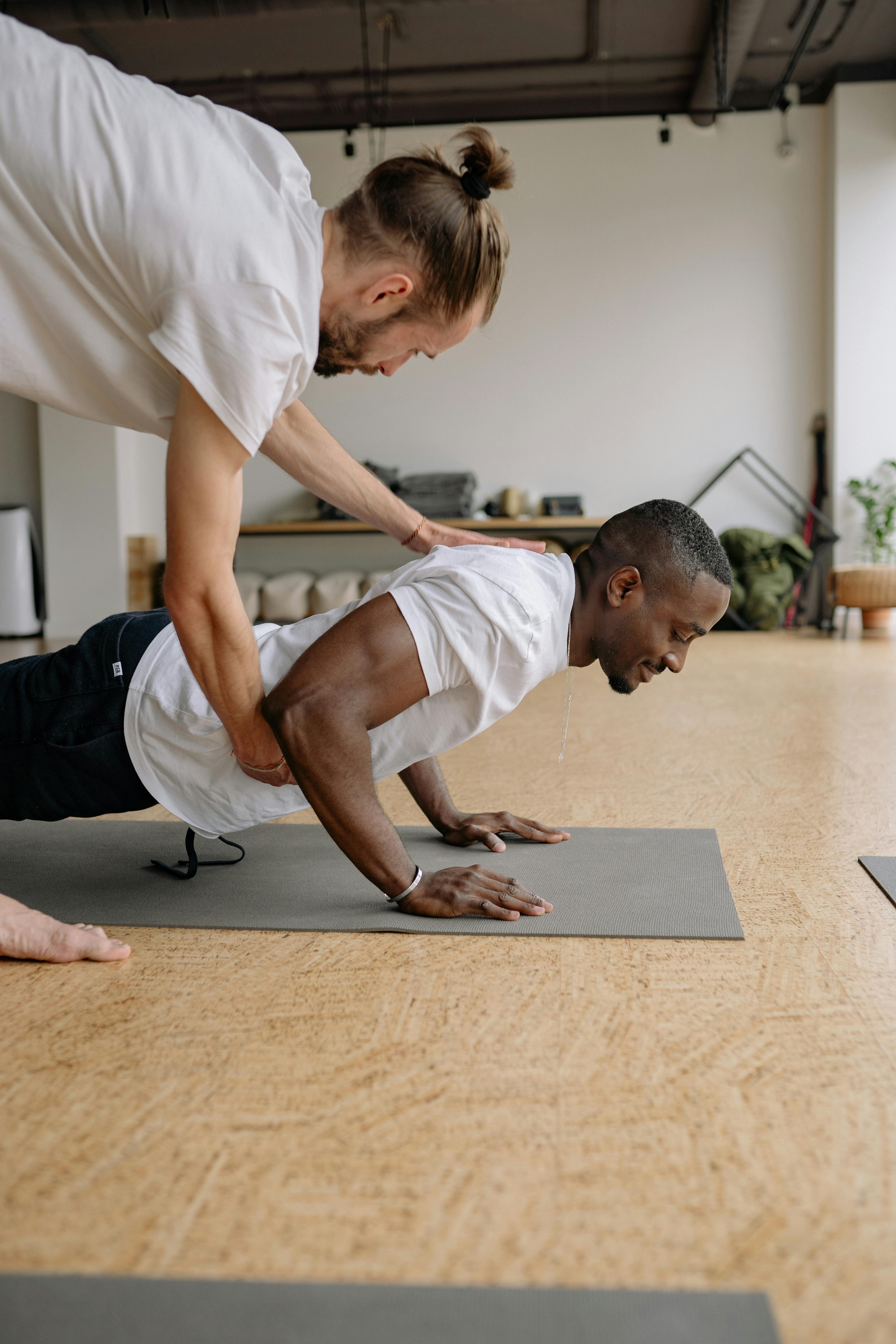 Fitness coach guiding a client through a push-up movement assessment.